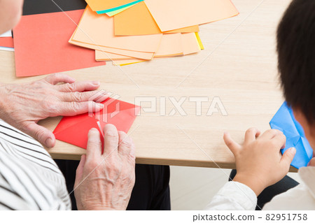 孫子和祖母玩摺紙 82951758