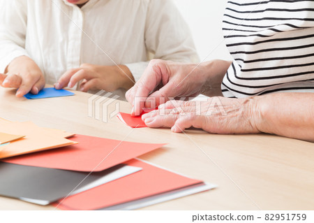 孫子和祖母玩摺紙 82951759