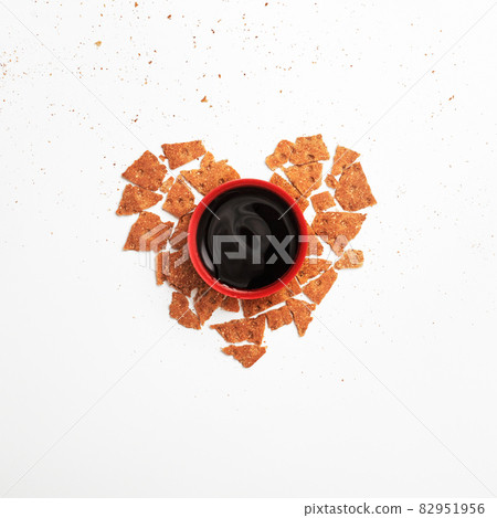 Minimalism. Red cup of coffee or tea among fresh Minimalism. Red cup of coffee or tea among fresh 82951956