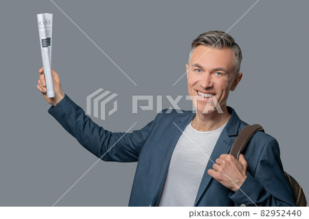 Happy man with newspaper in raised hand 82952440