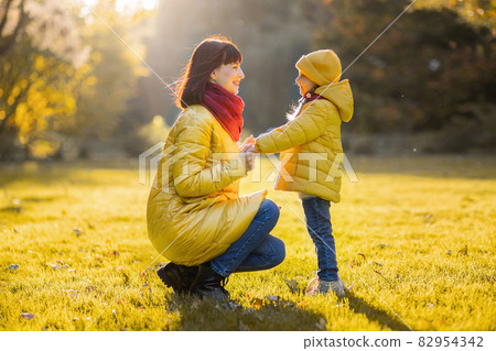 Mother and daughter in autumn yellow park. Mother and daughter in autumn yellow park. 82954342