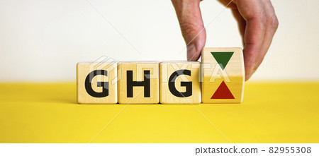 Greenhouse gas symbol. Concept words 'GHG, greenhouse gas' on cubes on a beautiful yellow table, white background. Business and GHG concept. Copy space. Greenhouse gas symbol. Concept words 'GHG, greenhouse gas' on cubes on a beautiful yellow table, white background. Business and GHG concept. Copy space. 82955308