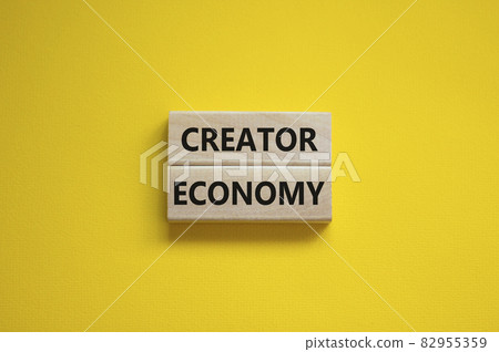 Creator economy symbol. Wooden blocks with words Creator economy on beautiful yellow background, copy space. Business and creator economy concept. 82955359