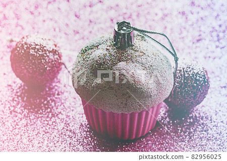Christmas pink toy on pink glitter. New Year's ornament. Christmas pink toy on pink glitter. New Year's ornament. 82956025