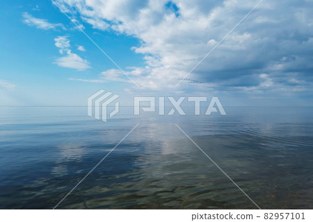 Cloudy sky and mirror water surface of calm sea 82957101