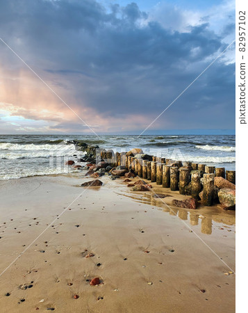Dramatic cloudy sky and Baltic sea beach at sunset 82957102
