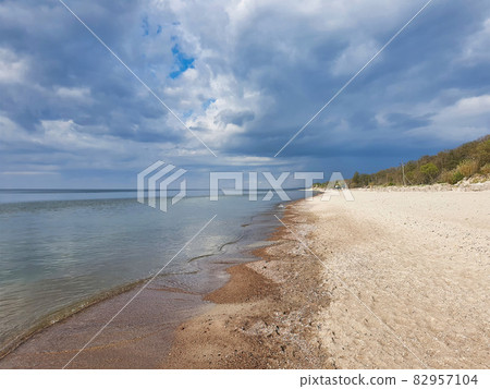 Baltic sea beach with calm waves and cloudy sky Baltic sea beach with calm waves and cloudy sky 82957104