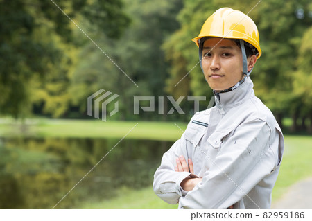 A young man wearing work clothes 82959186