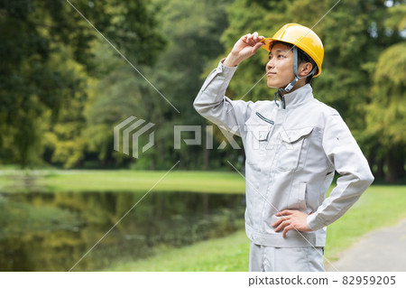 A young man wearing work clothes 82959205