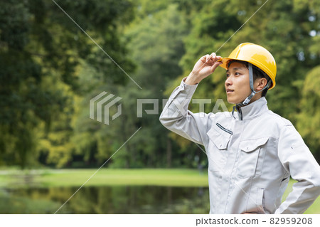 A young man wearing work clothes 82959208
