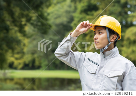 A young man wearing work clothes 82959211