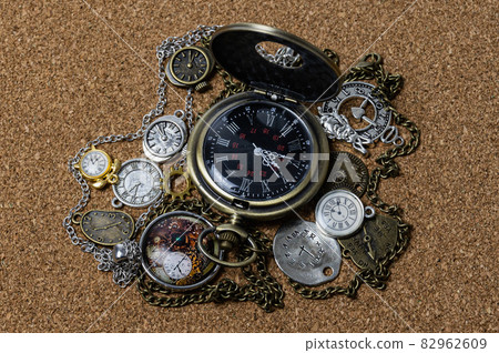 an analog watch in the form of various medallions with chains lies on a mat made of pressed leather 82962609