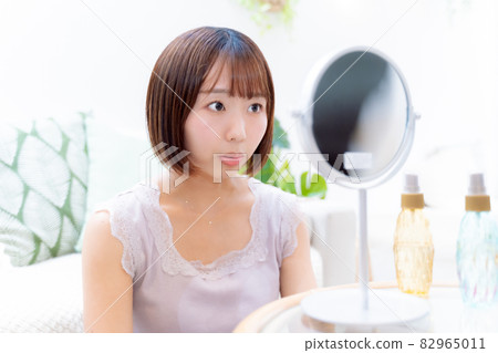 一位女士正在檢查她的皮膚狀況 82965011