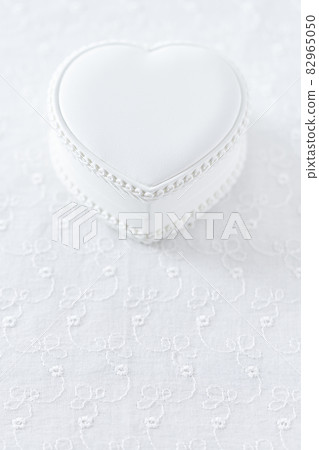 White heart-shaped case placed on lace cloth 82965050
