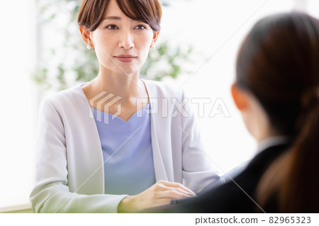 中年婦女與一位身著西裝的女士面對面坐著交談 82965323