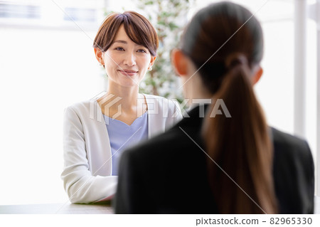 中年婦女與一位身著西裝的女士面對面坐著交談 82965330