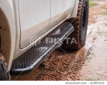 Dirty rear wheel of the off-road 4x4 truck at a countryside rural place in Rainy vibe, 4wd vehicle in rain, Selective focus shallow depth of field Dirty rear wheel of the off-road 4x4 truck at a countryside rural place in Rainy vibe, 4wd vehicle in rain, Selective focus shallow depth of field 82965620