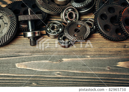 Car parts gears and bearings on wooden background Car parts gears and bearings on wooden background 82965738