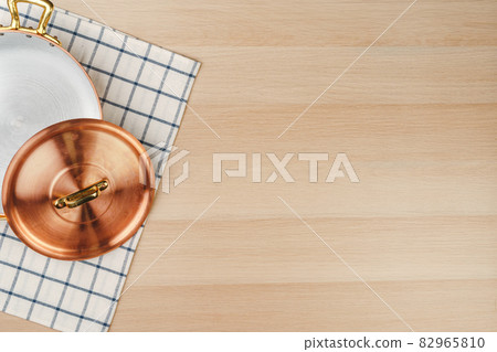 New copper cooking pot on wooden table, view from above 82965810