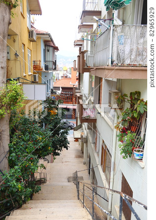 Narrow street in Alanya, steep stairs and balconies with flowers, Turkey, April 2021, cityscape 82965929