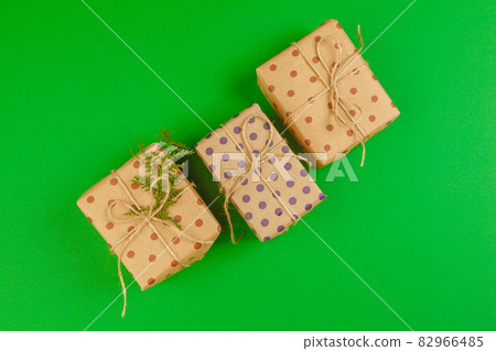 Decorated gift box on a green background, flat lay top view Decorated gift box on a green background, flat lay top view 82966485
