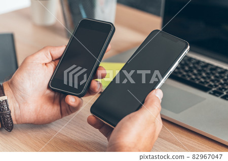 Man using mobile smart phone. Business man hands using cell phone at office desk. Man using mobile smart phone. Business man hands using cell phone at office desk. 82967047