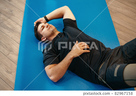 Young muscular caucasian handsome man doing abs exercises on mat Young muscular caucasian handsome man doing abs exercises on mat 82967158