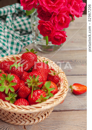 Basket of strawberry harvest on wooden table close up Basket of strawberry harvest on wooden table close up 82967206