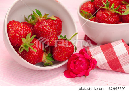 Bowl of strawberry harvest on wooden table close up Bowl of strawberry harvest on wooden table close up 82967291