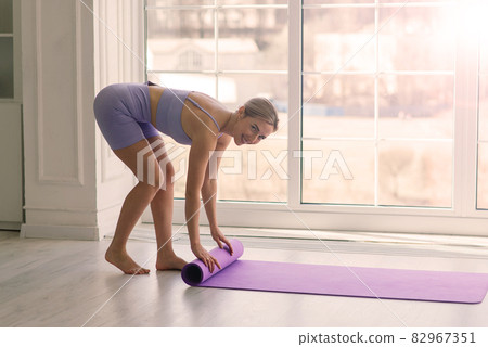 Health concept. Young beautiful woman does yoga exercise in the modern room 82967351