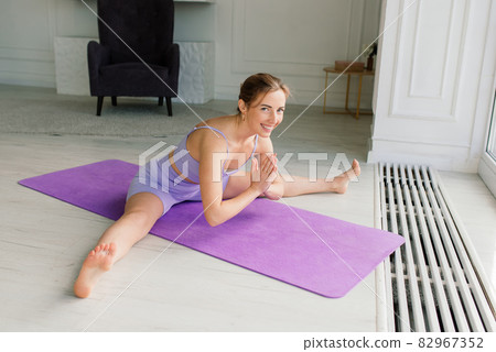 Health concept. Young beautiful woman does yoga exercise in the modern room 82967352