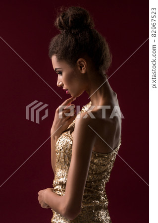 Fashion young African woman with make-up, in sexy gold dress. 82967523
