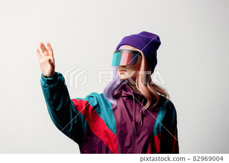 Beautiful woman in VR glasses and 80s sport suit on white background 82969004