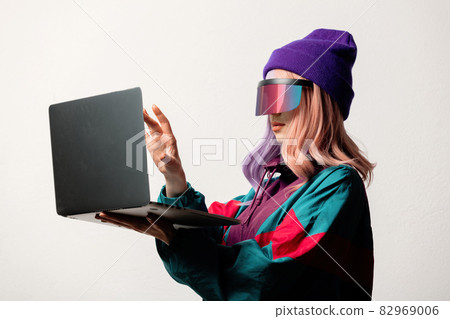 Beautiful woman in VR glasses with laptop and 80s sport suit 82969006