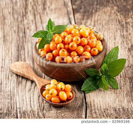 Sea buckthorn with mint on wooden backgrounds Sea buckthorn with mint on wooden backgrounds 82969166