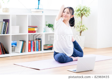 一名年輕女子在做在線瑜伽。 一名年輕女子在做在線瑜伽。 82969435