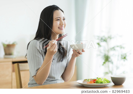 A young woman who makes a meal 82969483