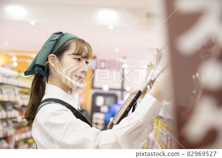 A female employee with a mouse shield who manages inventory at a supermarket A female employee with a mouse shield who manages inventory at a supermarket 82969527