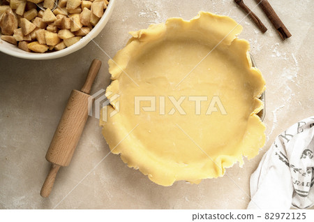 Tart dough or shortcrust pastry, in ceramic tart pan. Baking an apple rustic pie. Top view. Tart dough or shortcrust pastry, in ceramic tart pan. Baking an apple rustic pie. Top view. 82972125