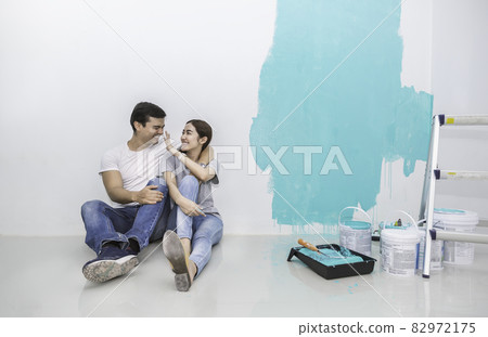 Portrait of happy smiling asian couple renovating painting wall house. Mother father repairing paint wall at home. Man and woman together love lifestyle concept with copy space. 82972175