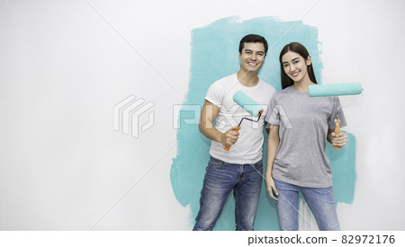 Portrait of happy smiling asian couple renovating painting wall house. Mother father repairing paint wall at home. Man and woman together love lifestyle concept with copy space. 82972176
