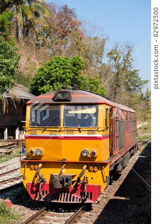 The diesel electric locomotive is parked at a small train station. The diesel electric locomotive is parked at a small train station. 82972500