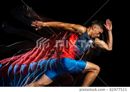 Cropped portrait of young athletic man, professional runner isolated over black background. Stroboscope effect. 82977521