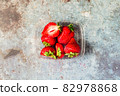 Strawberries in a plastic box on a blue metal background. Eco and Zero Waste Concept Copy space for text 82978868