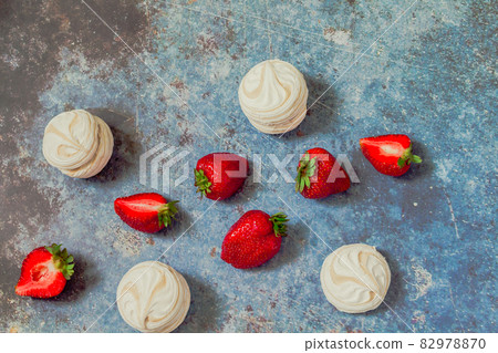 strawberries and marshmallows on a blue metal background. Healthy lifestyle and summer diet detox food concept. Copy space for text 82978870