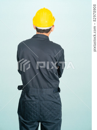 Man in coveralls helmet hardhat Man in coveralls helmet hardhat 82978908
