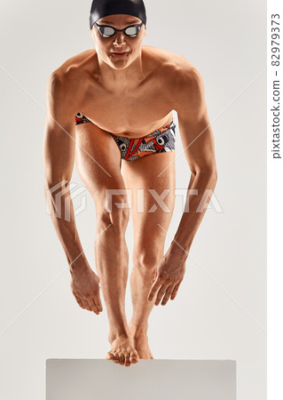 Portrait of a swimmer who is preparing for a jump. The concept of swimming and water games. Front view. Mixed media 82979373