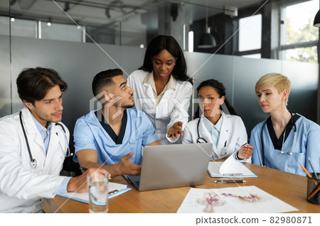 Puzzled doctors discussing medical cases, using laptop 82980871