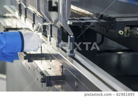 The technician operator working with hydraulic press brake bending machine. The technician operator working with hydraulic press brake bending machine. 82981895