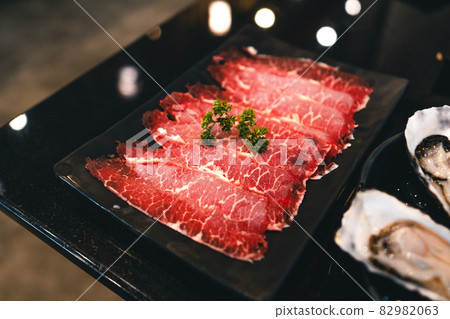 Sliced beef shabu in a black plate in a restaurant 82982063
